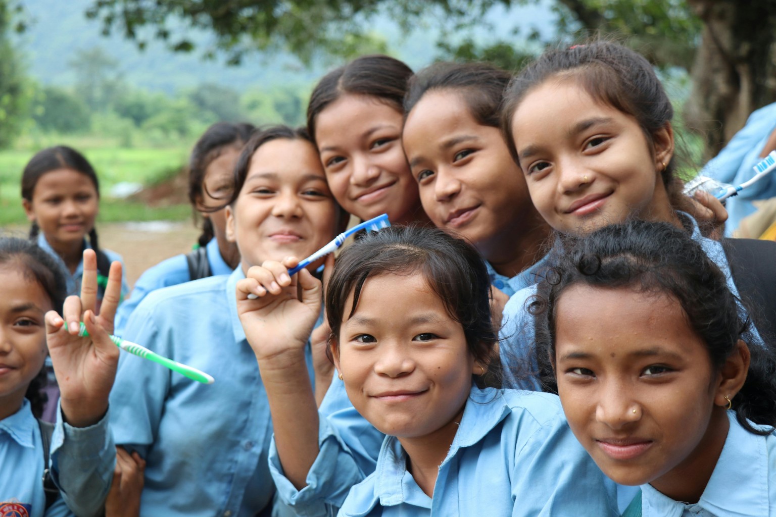 Group of girls smiling and holding toothbrushes