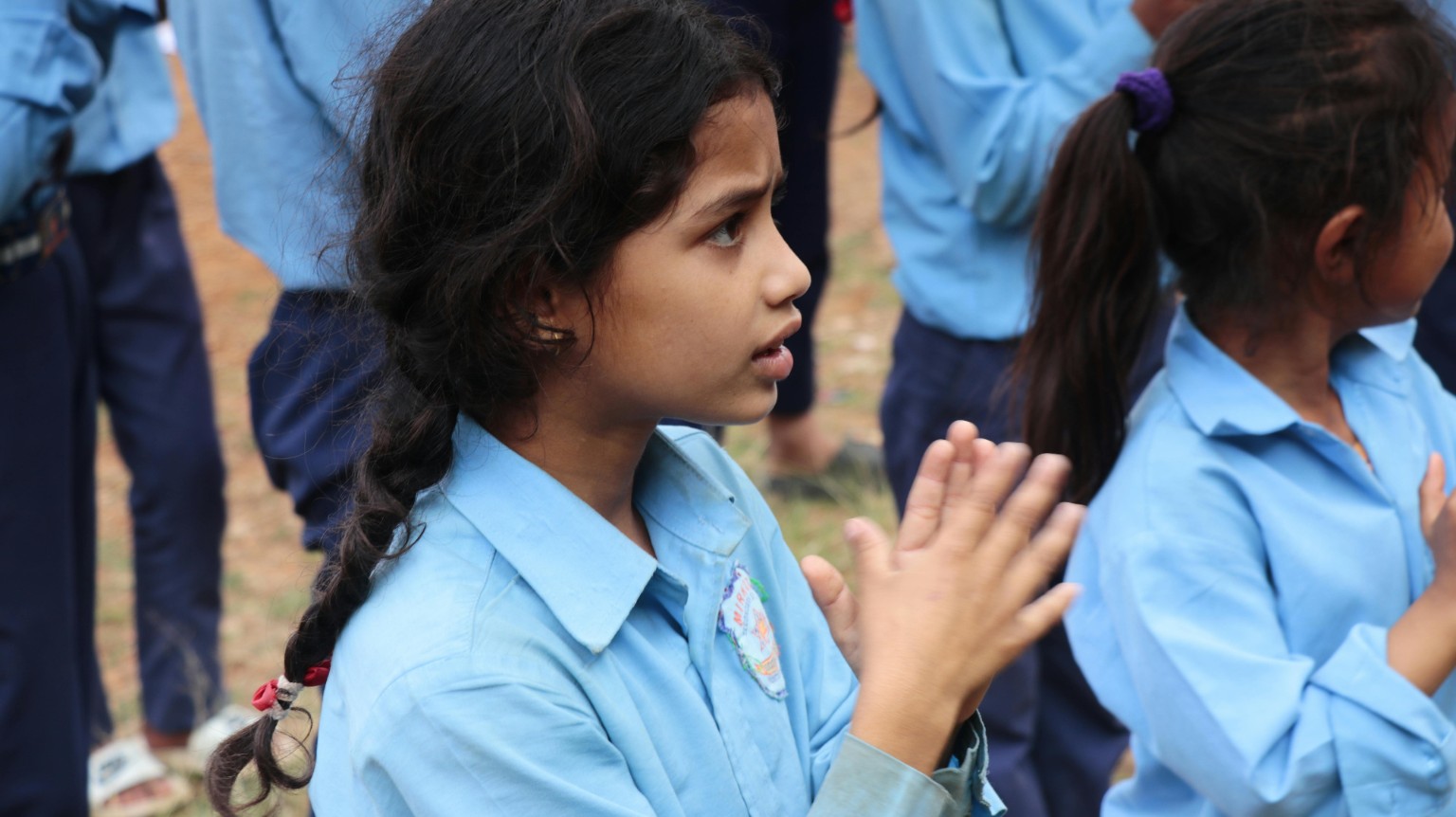 Children clapping together in school uniforms